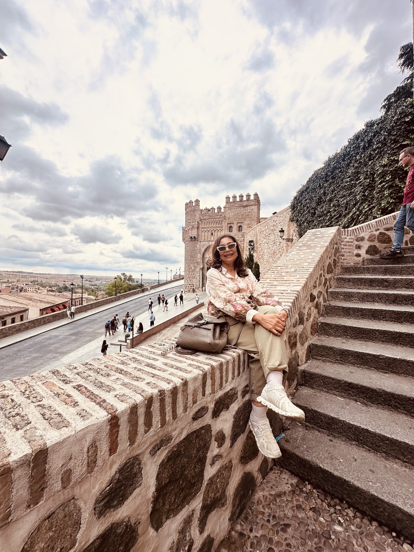 Alka seated beside the historic gate of Toledo